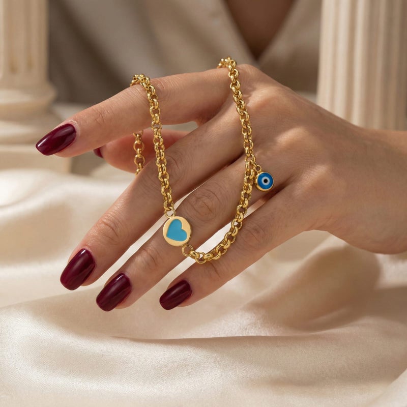 A gold-tone bracelet crafted from rust-resistant stainless steel, featuring a delicate turquoise heart design and a blue "eye" charm. Its modern design complements any look, and it has an adjustable clasp for a perfect fit. - Image 4